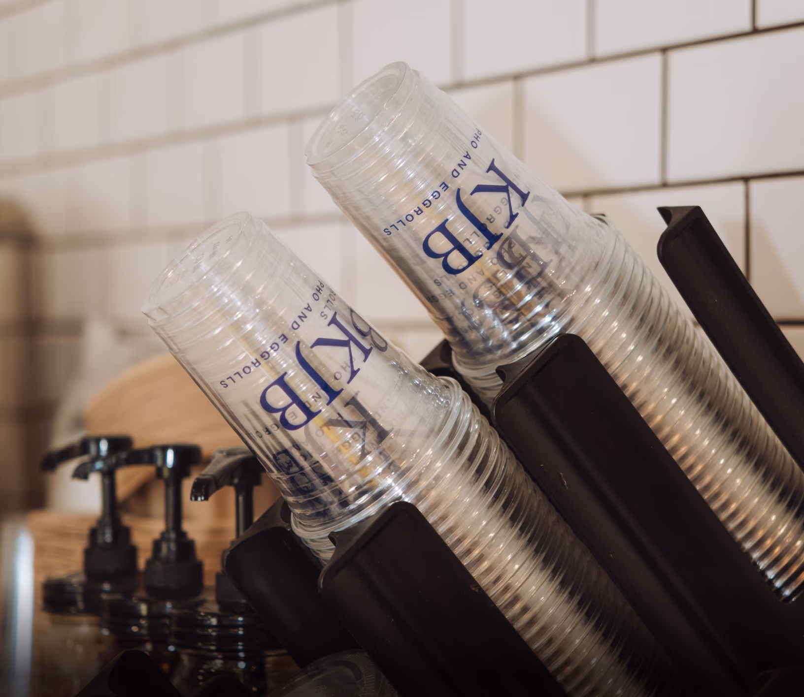 Stackable Clear Plastic Cups With Blue Logo in Countertop Dispenser, Custom Packaging Sample for Cafes and Events